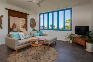a living room with a couch and a tv at Ulus - Tropical 1 Bedroom Ocean View Apartment by Triang Villas in Tanah Lot