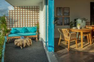 a living room with a table and a couch at Ulus - Tropical 1 Bedroom Ocean View Apartment by Triang Villas in Tanah Lot