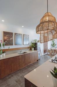 a kitchen with a sink and a large chandelier at Hossegor - Tropical 1 Bedroom Ocean View Apartment by Triang Villas in Tanah Lot +16 photos
