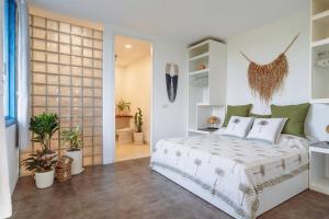 a bedroom with a bed in a room with plants at Hossegor - Tropical 1 Bedroom Ocean View Apartment by Triang Villas in Tanah Lot