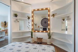 a bedroom with white shelves and a mirror at Pavones - Tropical Oceanfront 1 Bedroom Apartment by Triang Villas in Tanah Lot