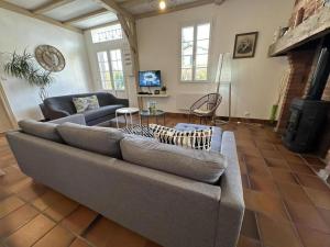 a living room with a couch and a fireplace at Cante alaoude in Linxe