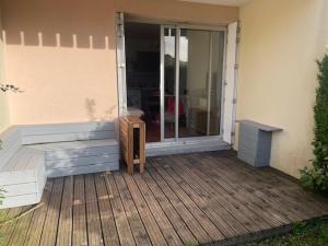 a porch with a bench and a sliding glass door at Un Cottage à la Mer in Le Pouliguen