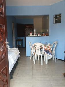 a bedroom with a table and chairs and a bed at House das Rosas in Beberibe