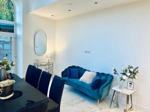 a living room with a blue couch and a table at The Bell Tower in Bonnybridge +36 photos