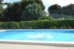 ein großer blauer Pool im Hof in der Unterkunft Un Cottage à la Mer in Le Pouliguen