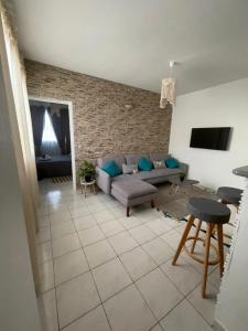 a living room with a couch and a tv at Appartement confortable avec vue sur mer à Le Robert in Le Robert