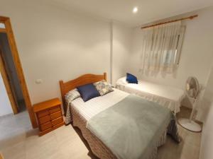 a small bedroom with two beds and a fan at Apartamento frente al mar 4 habitaciones in Oropesa del Mar