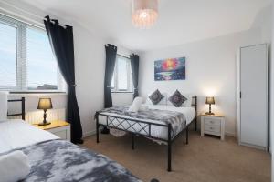 a bedroom with two beds and two windows at New! Spacious Retreat for 10 Perfect for Families! in Bowburn