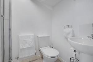 a white bathroom with a toilet and a sink at New! Spacious Retreat for 10 Perfect for Families! in Bowburn +34 photos