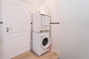 een witte wasmachine en droger in een witte badkamer bij Ferienwohnung Marder in Münster