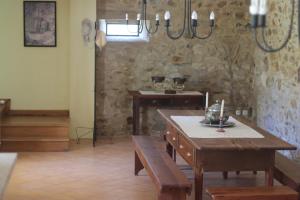 una sala da pranzo con un tavolo e un muro di pietra di Casa da Aldeia MGS a Laundos