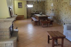 un soggiorno con tavolo, panche e divano di Casa da Aldeia MGS a Laundos
