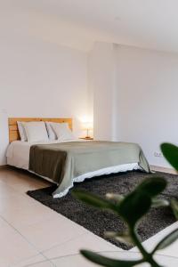 a bedroom with a large bed with a rug at Green House in Baleal