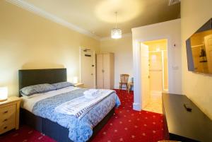 a bedroom with a bed with a blue and white comforter at Sailte House in Edinburgh