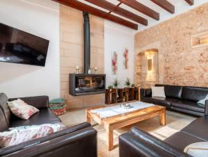 a living room with leather furniture and a fireplace at Cas Mercader in Algaida