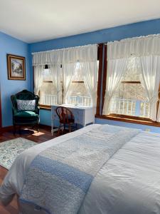 a bedroom with a bed and a desk and two windows at The Yorkshire Inn in Phelps