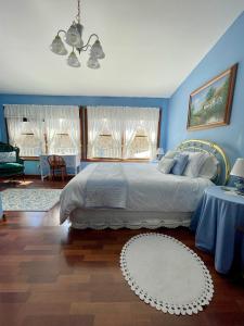 a bedroom with a large bed with blue walls at The Yorkshire Inn in Phelps +19 photos
