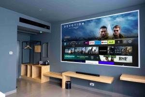 a large flat screen tv hanging on a wall at Drizzle Residence in Kuttālam