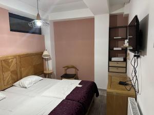 a bedroom with a bed and a tv in a room at Hotel cozy jano in Tbilisi City