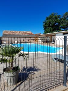 una valla alrededor de una piscina con una planta en Les 5 Étangs, en Brinon-sur-Sauldre