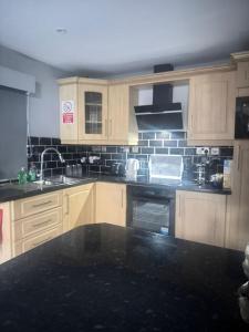 a kitchen with wooden cabinets and a black counter top at Elliotts Cabin in Grange +16 photos