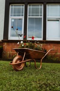 una carriola con dei fiori dentro davanti a una casa di Dawn Break Guest House a Largs