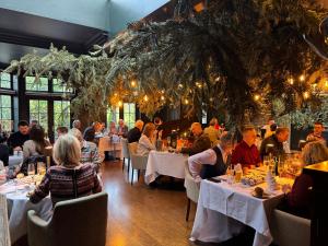 Eine Gruppe von Menschen sitzt an Tischen in einem Restaurant in der Unterkunft Simonstone Hall Hotel in Hawes