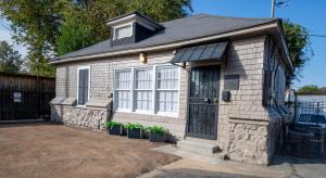 a small house with potted plants in front of it at Bluff City Luxe Cottage in Memphis