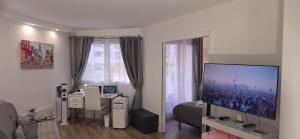 a living room with a large flat screen tv at Suite Prestige Paris-La Défense Balcon-Terrasse in Courbevoie