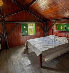 Cama en habitación de madera con 2 ventanas en Encontro dos Mares Chalés Lázaro, en Ubatuba 41 fotos más