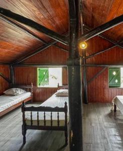 Un dormitorio con dos camas y techo de madera. en Encontro dos Mares Chalés Lázaro, en Ubatuba