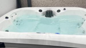 a white bath tub with blue water in it at Elliotts Cabin in Grange