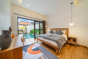 a bedroom with a bed and a swimming pool at Chic Brand New 2BDR Villa with Luxe Pool - The Ultimate Canggu Escape! in Kerobokan