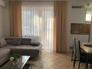 a living room with a couch and a table at Agoraapartment in Peje