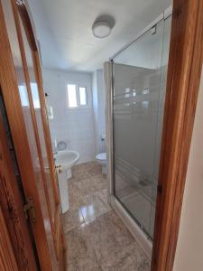 a bathroom with a glass shower and a toilet at 2ºA Escobar in Nerja +30 photos