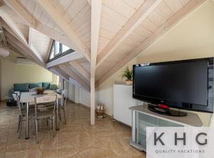 a living room with a tv and a table with chairs at Zoi's Sea View Apartments in Lixouri in Lixouri