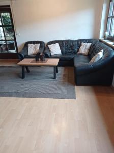 a living room with a black couch and a coffee table at Geräumige Ferienwohnung 90 sqm im Erholungsort in Bestwig +9 photos
