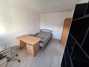 a small bedroom with a bed and a desk at Chambre chez l habitant proche Paris in Massy