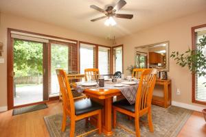 ein Esszimmer mit einem Tisch mit Stühlen und einem Deckenventilator in der Unterkunft Cole's Bay Vacation Retreat Petie's Cottage in YYJ