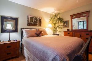 ein Schlafzimmer mit einem großen Bett und einer Kommode in der Unterkunft Cole's Bay Vacation Retreat Petie's Cottage in YYJ