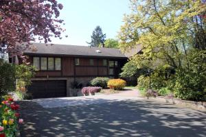 eine Auffahrt, die zu einem Haus mit einer Garage führt in der Unterkunft Cole's Bay Vacation Retreat Petie's Cottage in YYJ