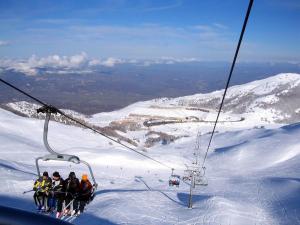 a group of people on a ski lift in the snow at Bilocale in residence San Nicola 3 in San Massimo