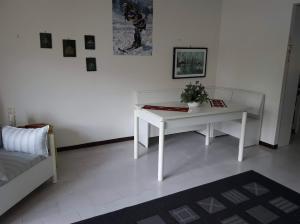 a living room with a white table and a couch at Bilocale in residence San Nicola 3 in San Massimo