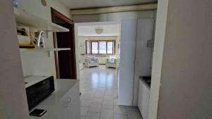 a room with a kitchen and a living room at Bilocale in residence San Nicola 3 in San Massimo +9 photos