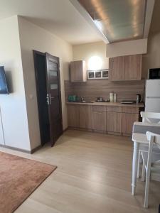 a kitchen with wooden cabinets and a white refrigerator at Noclegi Opole-Chmielowice Apartament B in Opole