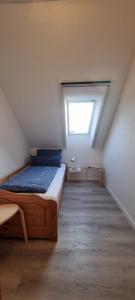 ein Schlafzimmer mit einem Bett und einem Fenster im Dachgeschoss in der Unterkunft Gartenwohnung in Norden + 2 Fotos
