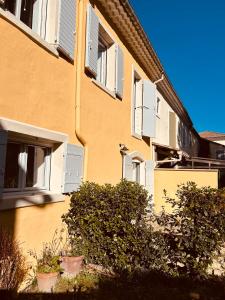 a building with windows and bushes in front of it at "ENTRE LA VIGNE et L'OLIVIER" in Taulignan