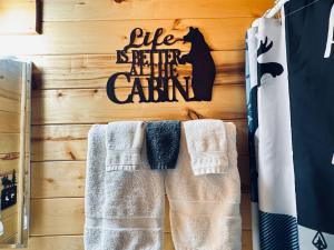 a rack of towels hanging on a wall with a cat sign at Pet Friendly Retreat in Rim Country! With a Spa! in Mogollon Airpark +19 photos
