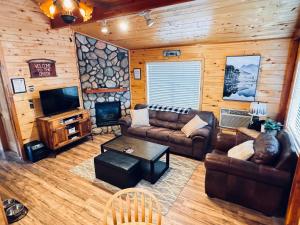 a living room with couches and a tv and a fireplace at Pet Friendly Retreat in Rim Country! With a Spa! in Mogollon Airpark